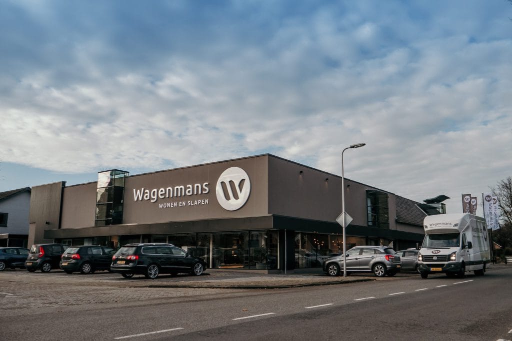 Buitenkant van het pand van Wagenmans wonen en slapen in Lemelerveld. Met grote letters staat het logo op het pand van de woonwinkel.