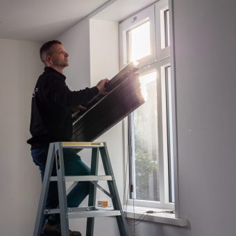Twan hangt raamdecoratie op bij klanten